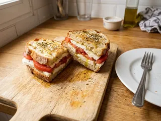 Ilustración de marca de una tabla con tostadas de queso y tomate