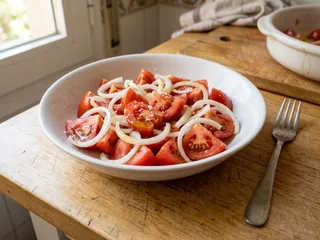 Ilustración de marca de un plato con ensalada de tomate y cebolla